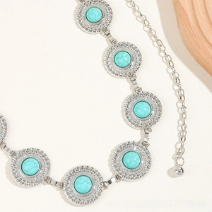 Detailed macro view of bohemian silver metal belt with turquoise stone circular pendants