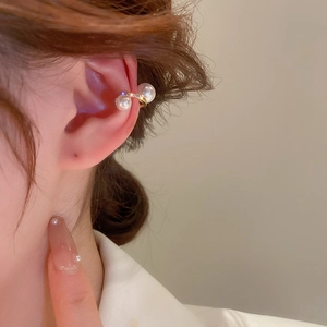 Close-up of gold-plated twisted ear cuff with white pearls and sparkling zircons