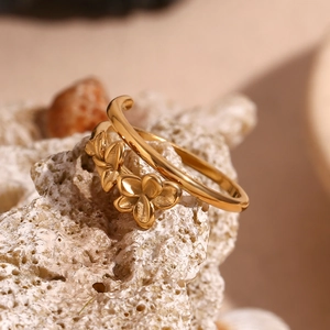 Close-up of 18K gold-plated double-layer open ring featuring three small flowers on coral stone