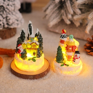 Close-up of lighted resin gingerbread house with Santa Claus and Snowman Christmas decor