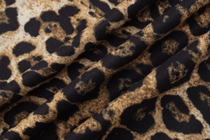 Détail macro du tissu en maille imprimé léopard montrant la texture et le drapé doux