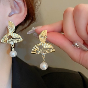 Boucles d'oreilles éventail dorées élégantes avec perles sur modèle porté