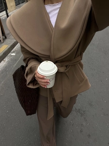 Detailaufnahme von camelfarbenem Wollmantel mit Revers und Gürtel im Streetstyle-Look