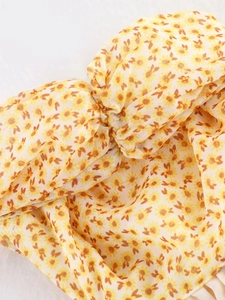 Macro del tessuto giallo a stampa floreale con pieghe e trame sottili e leggere