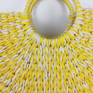 Minimalist straw woven round tote bag with circular handles for summer beach vacations