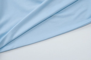 Macro shot of light blue ribbed knit fabric showing soft texture and detailed vertical patterns