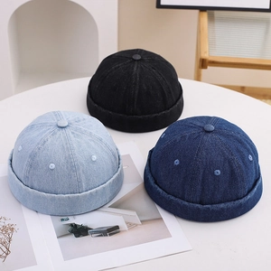 Three colors of denim miki hats in black and blue shown on a white table in soft light