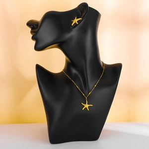 Starfish jewelry set with gold pendant necklace and stud earrings on black bust