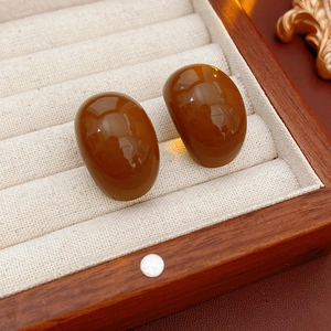 Brown oval resin earrings in a beige velvet wood jewelry box with high-gloss finish