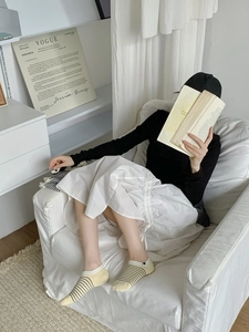 Detail of low-cut striped socks with black heart embroidery in a cozy home setting