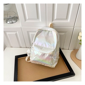 Detail showing laser holographic silver backpack with a cute white plush bear pendant