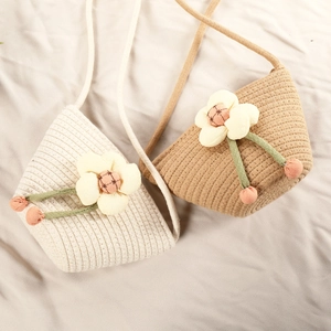 Detailed view of woven straw bags in beige and khaki with 3D floral decorations