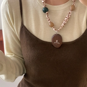 Close-up of leopard print cord necklace with resin beads and saturn pendant detail