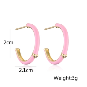 Detail view of pink enamel C-shaped gold hoop earrings with small clear gemstone