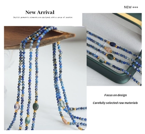 Detail of multilayered beaded necklace with blue faceted stones and colorful gems in a box