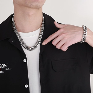 Close-up of a man wearing a silver 16mm thick curb chain necklace and bracelet set