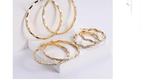 Detail showing three sizes of gold wavy hoop earrings with micro-inlaid rhinestones