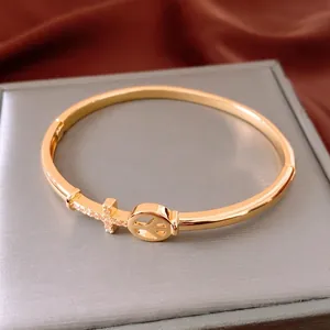 18K gold plated arrow cross bangle with peace charm on a premium jewelry box