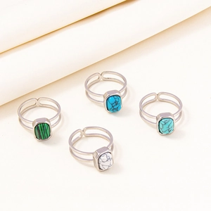 Detailed view of four stainless steel rings with colorful rectangular gemstones