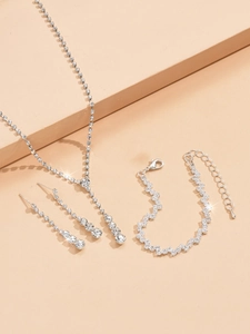 Close-up of sparkling bridal jewelry set with silver necklace and tassel earrings