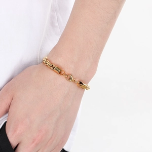 Close-up of gold stainless steel twisted chain bracelet with lobster clasp on wrist