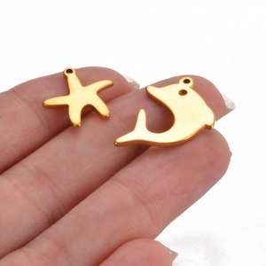Gold stainless steel starfish and dolphin pendant charms displayed on fingers for size