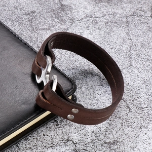 Close-up of brown braided leather bracelet with silver stainless steel anchor hook clasp