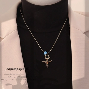 Detail of vintage bull skull necklace with blue evil eye bead on a model sweater