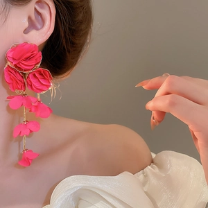 Close-up of elegant oversized rose chiffon tassel earrings with gold-rimmed fabric petals