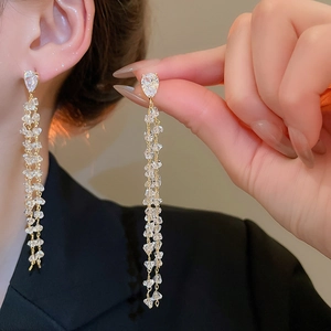 Detail of 18k gold plated tassel earrings with zirconia crystals showing movement