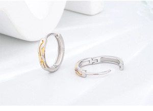 Macro detail of S925 sterling silver hoop earrings with gold-plated wavy texture and stamp