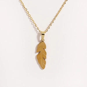 Detailed view of the gold feather pendant necklace with minimalist steel chain