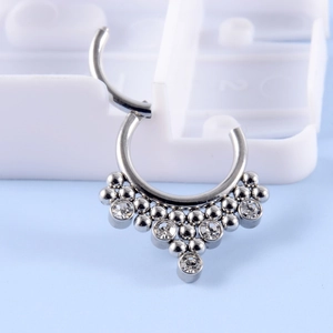 Macro shot of silver stainless steel hinged hoop ring with teardrop zirconia crystals