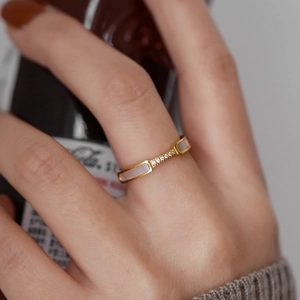 Minimalist gold titanium ring with mother of pearl and small diamonds on hand