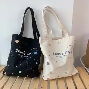 Détail de sacs cabas en toile noir et crème avec imprimé Starry Sky et pois