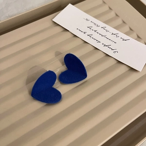 Macro shot of Klein blue heart earrings with premium velvet flocking texture on tray