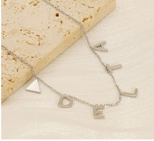 Vue détaillée du collier en acier titane argenté avec pendentifs lettres sur pierre