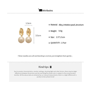 Detail view of round pearl earrings with golden lava texture and 3.5x1.5cm dimensions