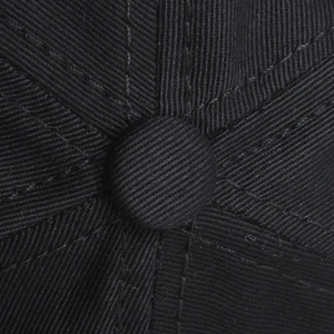 Macro shot of the black cotton baseball cap top button and detailed twill stitching