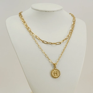 Detail of 18K gold double-layered paperclip necklace featuring a round letter H pendant