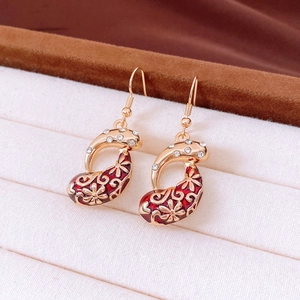 Close-up of vintage gold flower earrings with red enamel and sparkling rhinestones