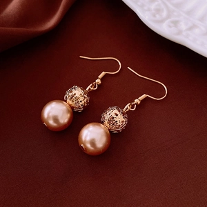 Detail of vintage round ball glass pearl earrings with gold hollow metal beads