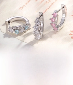 Macro detail of geometric earrings with micro-set zircon in pink, white, and blue tones