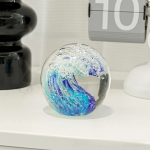Macro detail of a glass crystal ball featuring an artistic ocean wave interior sculpture