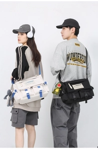 Detail of multi-pocket canvas messenger bags in white and black with adjustable straps