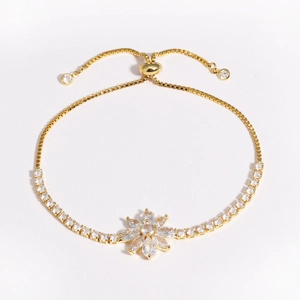 Détail du bracelet ajustable plaqué or avec pendentif fleur orné de zircons cubiques
