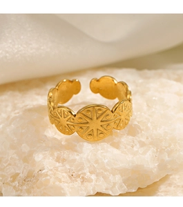 Detail of adjustable gold starburst ring placed on white crystal with silk background