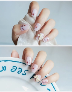 Detail of tulip nail stickers featuring a 3D white bow and soft pink french floral art