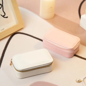 Mini portable leather jewelry box in white and pink with secure zipper closure