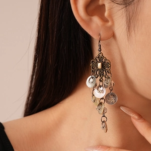 Detail view of vintage Chinese knot earrings with tassels on a model's ear